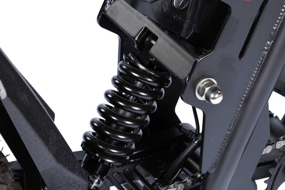GT54 Pro black metal coil spring rear suspension shock absorber on an off-road electric mini motorcycle frame close-up.