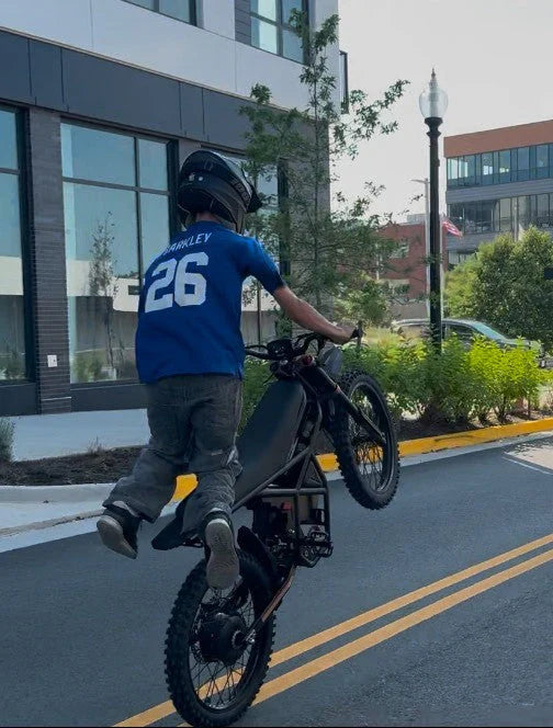 Rider performing wheelie on GT73 Pro electric motorbike in urban setting