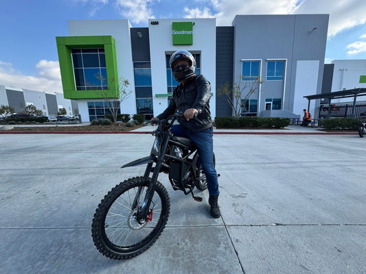 Person wearing helmet and jacket riding an electric bike outside a modern commercial building for PICC insurance policy promotion