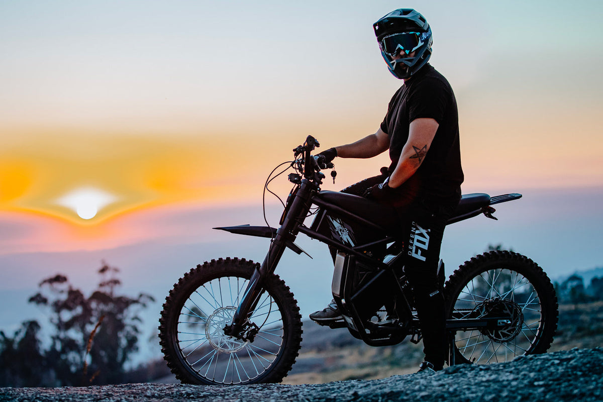 GT73 Electric Dirt Bike with rider at sunset - Off-road E-bike Performance