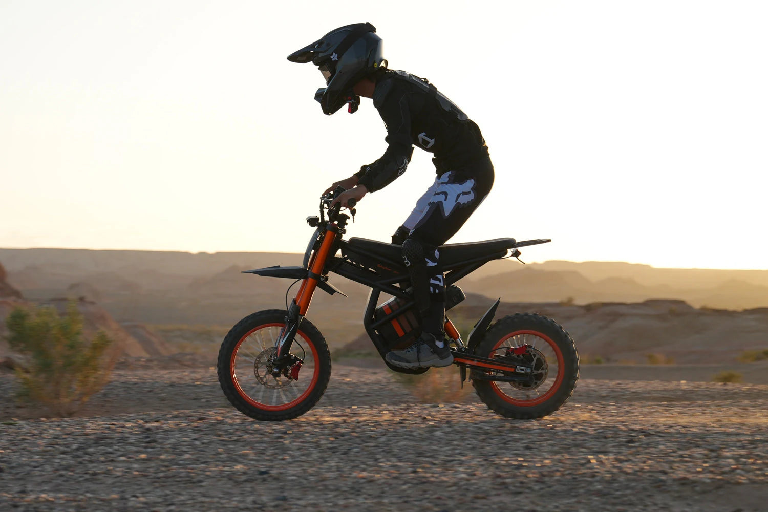 Riding’times GT54 com piloto de capacete em uma trilha off-road ao pôr do sol